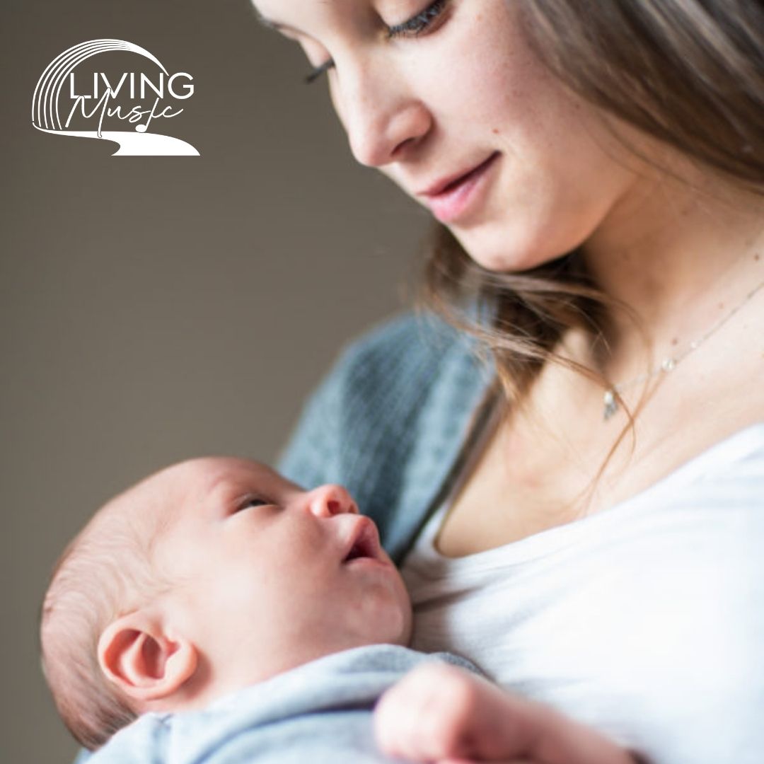 A caregiver holds and looks at a newborn baby.