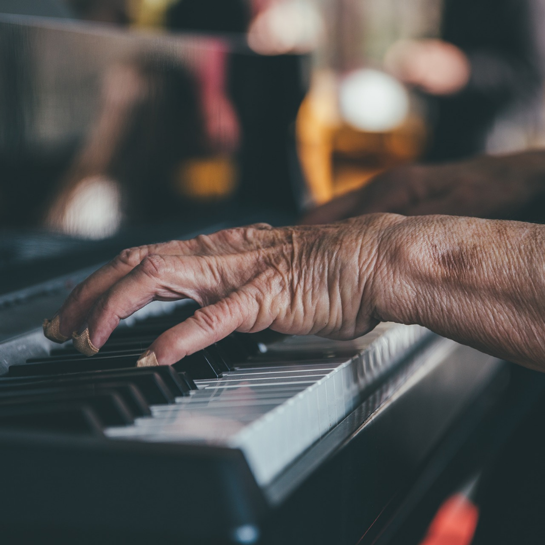 An older adult playing the piano.